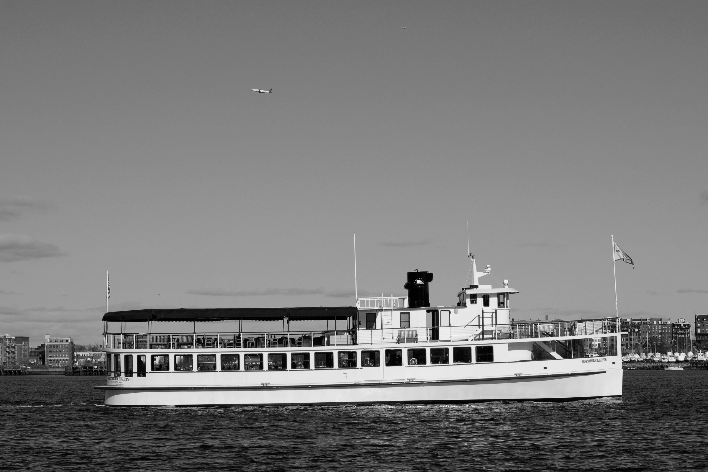 A passenger ferry crossing the water in black and white.