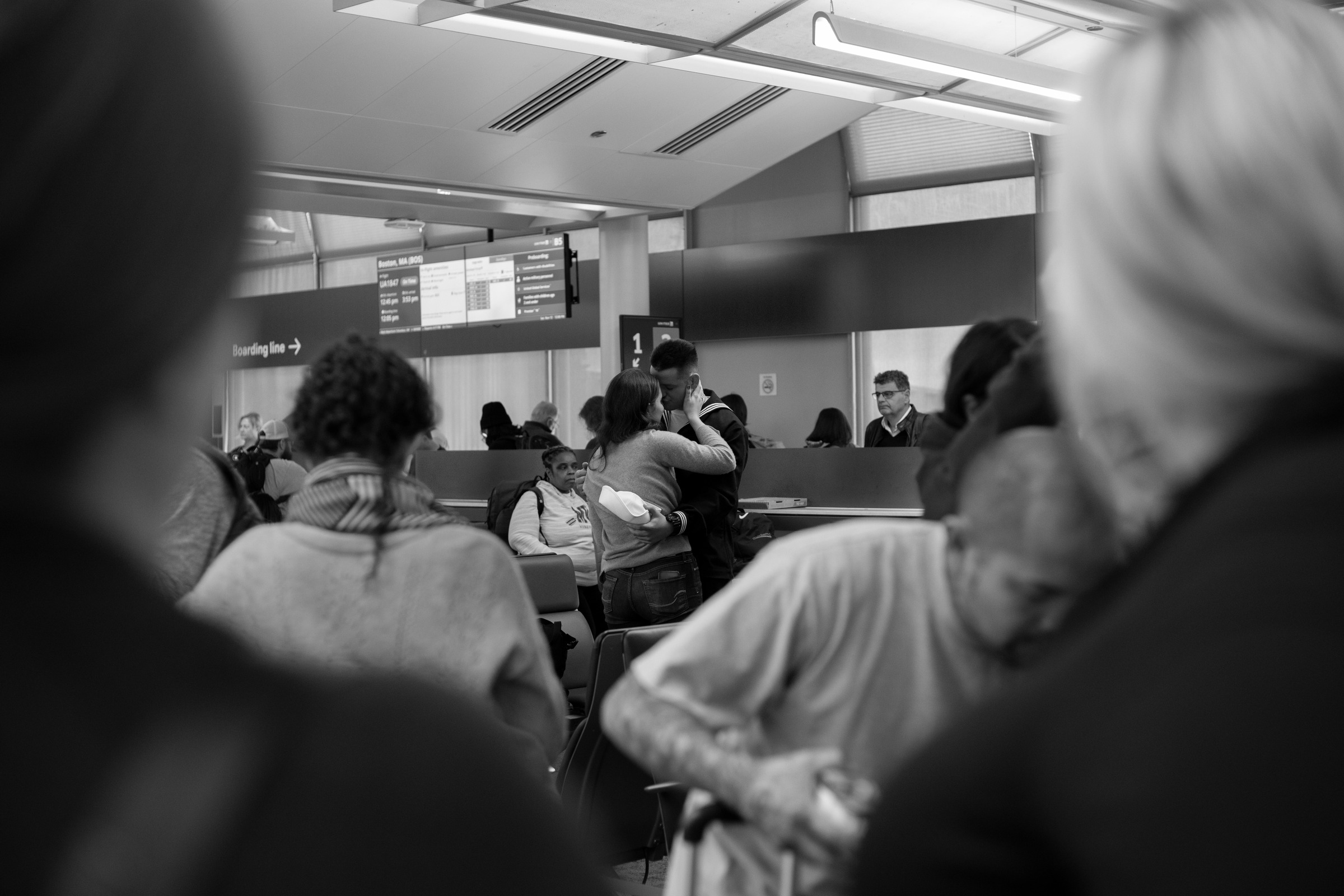 Passengers seated together inside a shared transport waiting area.