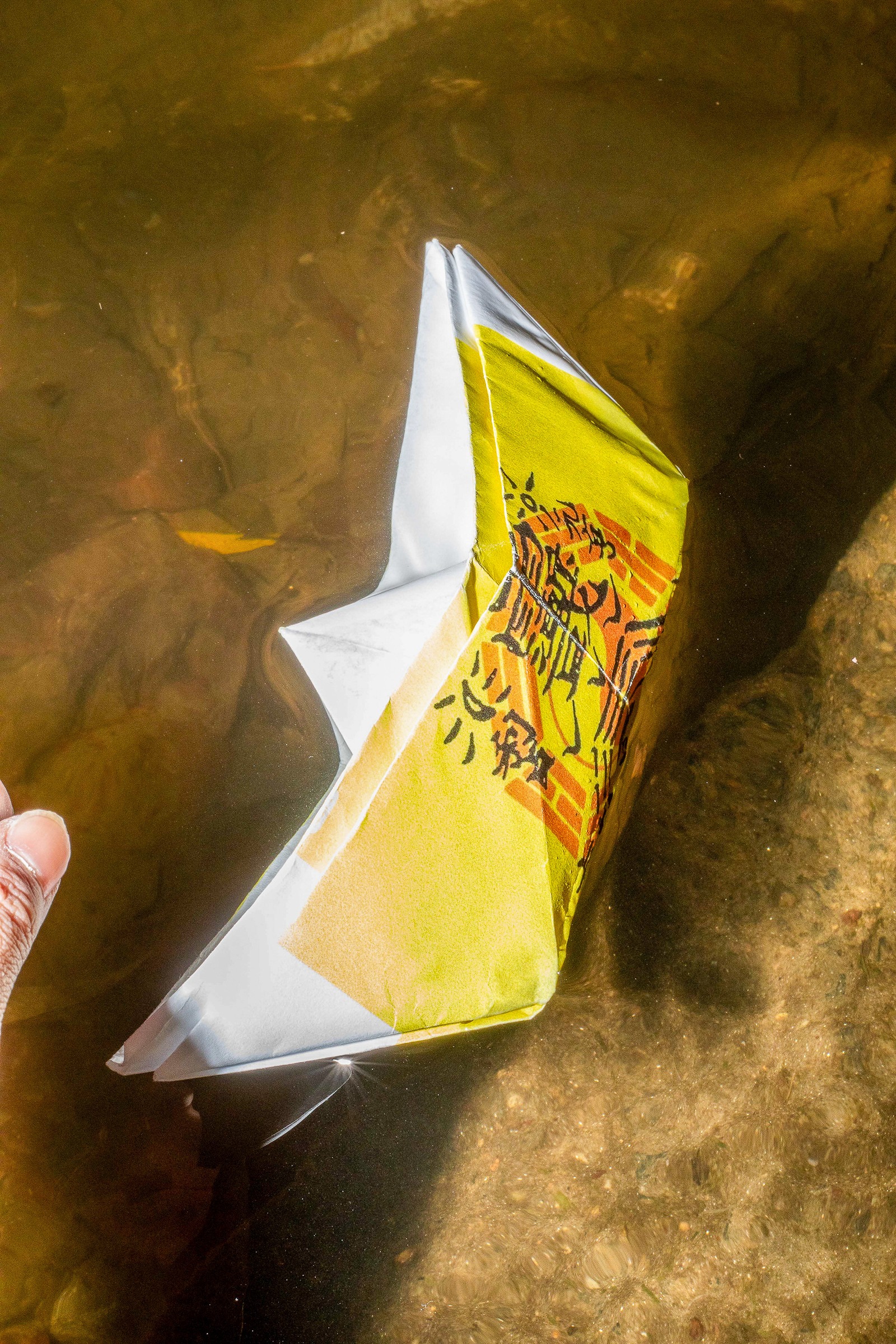 A folded yellow and white paper object in warm light.