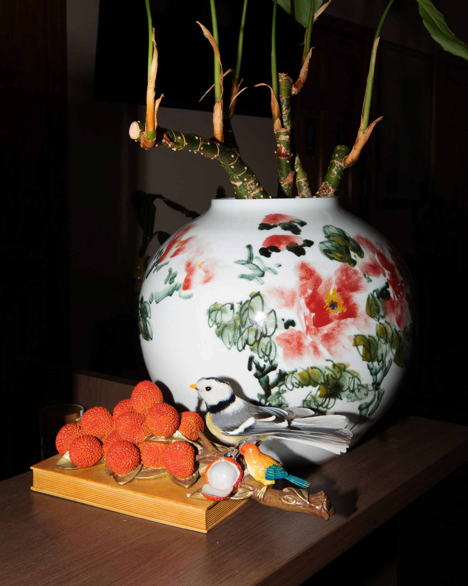 A decorated ceramic vase with branches and small objects.