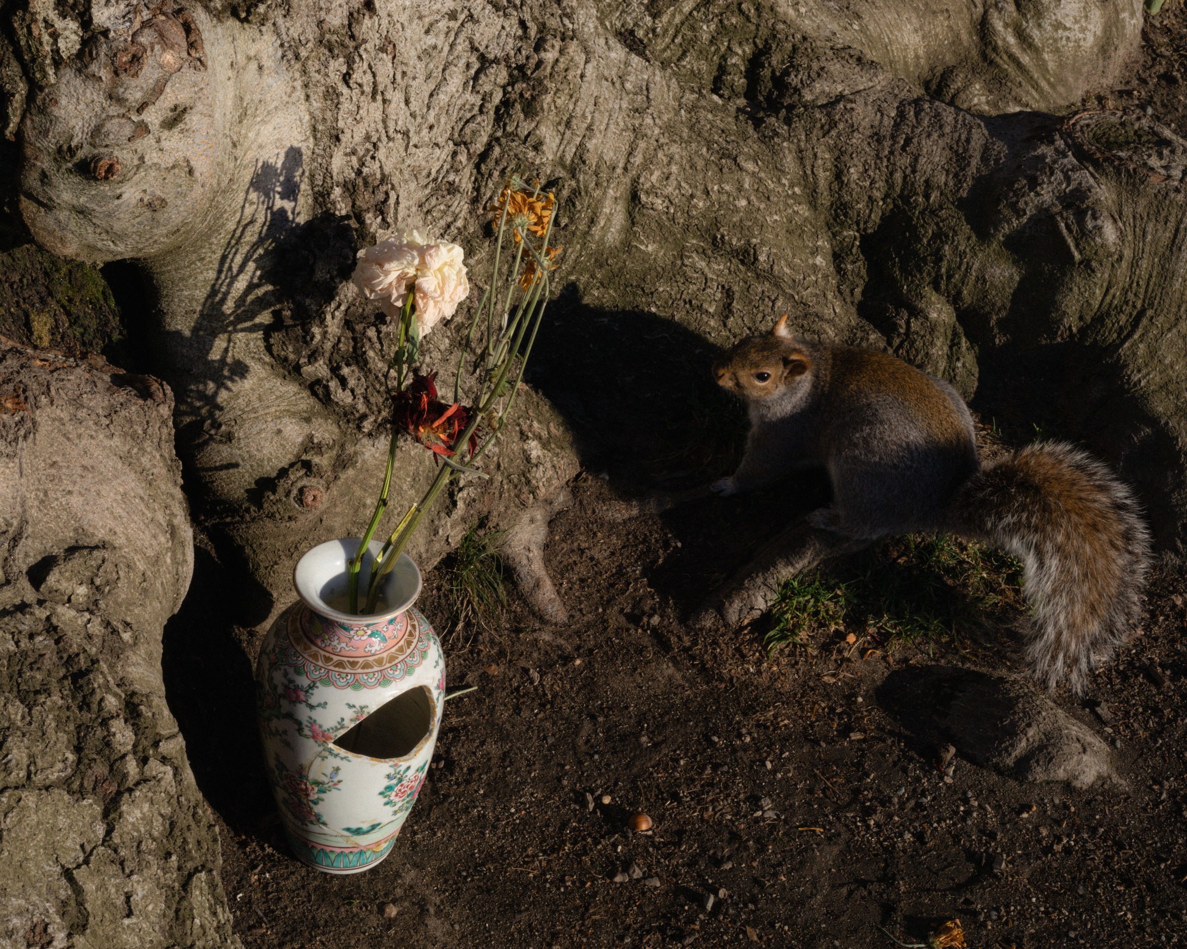 A ceramic vessel with incense beside a tree and resting animals.